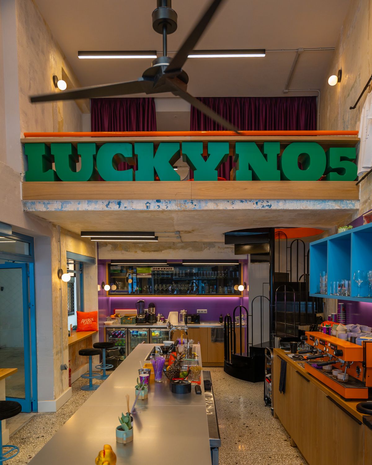 Το εσωτερικό του Lucky №5 με την πράσινη επιγραφή και τον μακρύ πάγκο